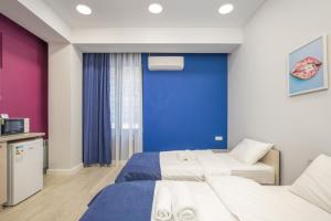 a hotel room with two beds and a blue wall at Hotel Armeni in Yerevan
