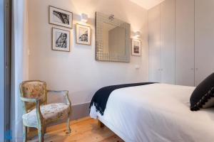 a bedroom with a bed and a chair and a mirror at Quinta da Boa Vista Garden & Terrace in Porto