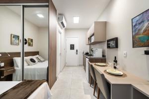 a small apartment with a bed and a kitchen and a room at Jaques Pilon | Studio Centro | Perto de Tudo in São Paulo