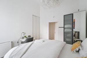 a white bedroom with a large bed and a mirror at Chic apart terrace garden parking in Asnières-sur-Seine