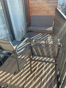 2 chaises et une table sur un balcon dans l'établissement Velaux Moderne appart 4 pers - Tout équipé avec terrasse à 15 min plage et aéroport, à Velaux