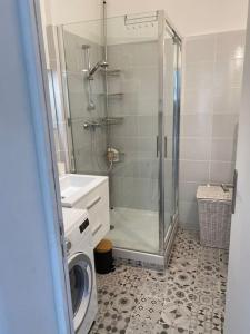 La salle de bains est pourvue d'une douche et d'un lave-linge. dans l'établissement Velaux Moderne appart 4 pers - Tout équipé avec terrasse à 15 min plage et aéroport, à Velaux