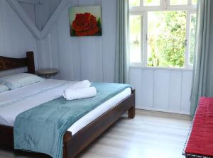 um quarto com uma cama com um banco vermelho e uma janela em Recanto Hellmann em Gaspar