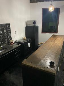 eine Küche mit einem Holztisch und einem Kühlschrank in der Unterkunft Casa da Cida in Tiradentes