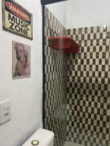 ein Bad mit WC und ein Schild an der Wand in der Unterkunft Casa da Cida in Tiradentes