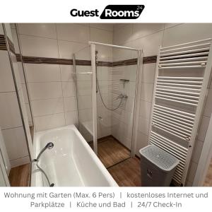 a bathroom with a shower and a bath tub at Wohnung mit Garten EG - GuestRooms24 - Marl in Marl