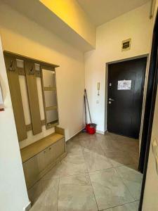 a hallway with a black door and a room with a tiled floor at Cazare Iasi Palas Apartment in Iaşi