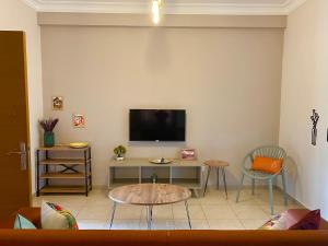 uma sala de estar com uma mesa e uma televisão na parede em Lavender Homes, Walled City em Famagusta