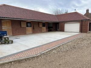 a brick house with a garage and a driveway at The Stable Room at The Grange in Lincolnshire
