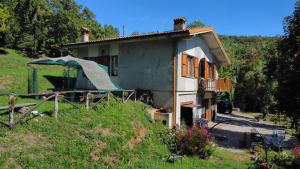 una pequeña casa con un cenador frente a ella en Oasi di pace e natura, en Montecucco