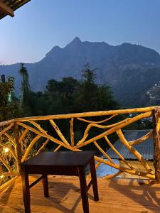 a bench on a deck with a view of the mountains at Cabaña Tzanjuyu in San Juan La Laguna