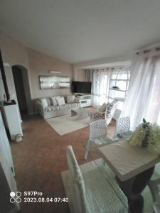 a living room with a couch and a table and chairs at Villetta Isor con piscina in Costa Paradiso