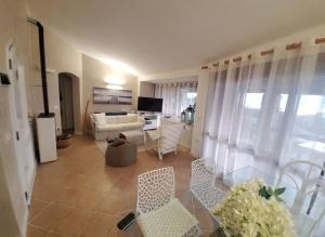 a living room with a couch and a table and chairs at Villetta Isor con piscina in Costa Paradiso