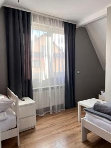 una camera da letto con una grande finestra con tende di Pokoje u Jasia i Małgosi a Skawa