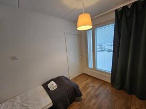 a bedroom with a bed and a large window at Kotimaailma - Tilava Kolmio Kruunuvuorenrannassa in Helsinki
