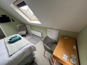 una camera con letto, tavolo e lucernario di Cotswold Retreat - Private & Peaceful 