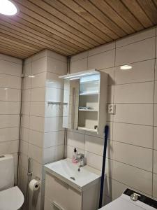 y baño con lavabo, aseo y espejo. en Kotimaailma - Tilava Kolmio Kruunuvuorenrannassa en Helsinki