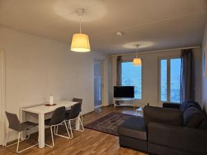 a living room with a couch and a table with chairs at Kotimaailma - Tilava Kolmio Kruunuvuorenrannassa in Helsinki