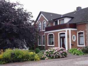 a brick house with flowers in front of it at Ferienhof Jens Ferienwohnung 3 in Kronsgaard