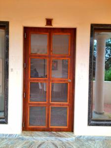 een houten deur naar een huis met een pilaar bij Shiv villa in Saralgaon
