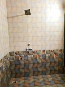 een betegelde douche met een kraan in de badkamer bij Shiv villa in Saralgaon