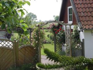 a wooden gate leading to a garden with flowers at Ferienhof Jens Ferienwohnung 3 in Kronsgaard