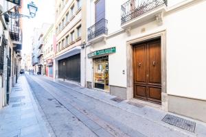 una calle vacía con una puerta de madera en un edificio en Apartamento Gracia, en Granada