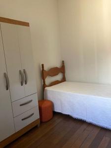 Dormitorio pequeño con cama y vestidor en Quartos em casa no Clelia Bernardes en Viçosa