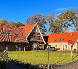 a building with an orange roof and a car in front at Fewo Wolke in Menslage