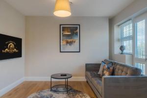 a living room with a couch and a table at Cozy 2 Bed Retreat - Allocated Parking in Windsor