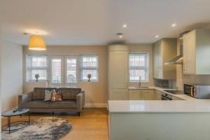 a living room with a couch and a kitchen with windows at 2 Bed Retreat Parking VAT Q - By Tempstay in Windsor