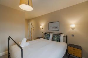 a bedroom with a large white bed with two pillows at Cozy 2 Bed Retreat - Allocated Parking in Windsor