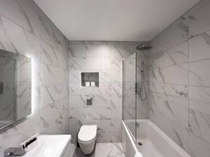 a white bathroom with a tub and a toilet and a sink at 2 Bed Retreat Parking VAT Q - By Tempstay in Windsor