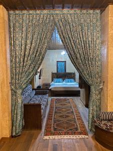 ネヴシェヒルにあるLovely Cappadocia Hotelのカーテンとラグ付きの客室内のベッド2台