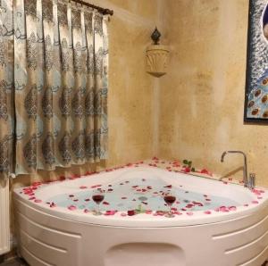 a bath tub with two glasses of wine in it at Lovely Cappadocia Hotel in Nevşehir