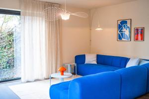 um sofá azul numa sala de estar com uma janela em Living Lodges - Durbuy em Durbuy