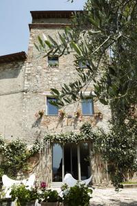 een stenen gebouw met ramen en bloemen erop bij Il Ghiottone Umbro in Todi