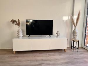 een tv op een witte kast in een woonkamer bij Fewo Tenne in Menslage
