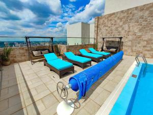 a swimming pool with blue chairs and a swimming pool at Elite Residence 1 bedroom Westlands with views, gym &pool in Nairobi