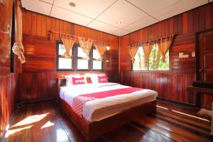 a bedroom with a bed in a wood paneled room at OYO 476 Ban Rimnam Resort in Nakhon Pathom
