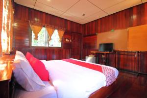a bedroom with a large bed with red pillows at OYO 476 Ban Rimnam Resort in Nakhon Pathom