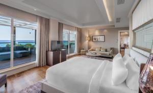 a bedroom with a large white bed and a large window at Rixos Premium Tekirova - The Land of Legends Access in Tekirova