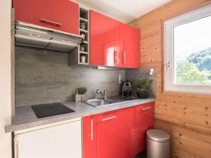 a red kitchen with a sink and a window at Appartement Saint-Lary-Soulan, 3 pièces, 6 personnes - FR-1-296-142 in Saint-Lary-Soulan