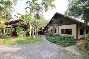 a house with a pathway next to a building at OYO 476 Ban Rimnam Resort in Nakhon Pathom
