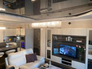 een woonkamer met een bank en een flatscreen-tv bij Top-notch apartment with sea view, bbq and Jacuzzi in St Julian's