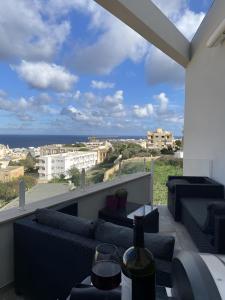 een balkon met banken en uitzicht op de oceaan bij Top-notch apartment with sea view, bbq and Jacuzzi in St Julian's
