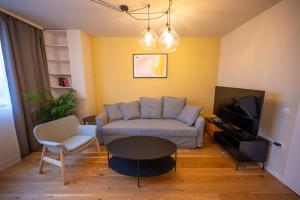 ein Wohnzimmer mit einem Sofa und einem Tisch in der Unterkunft Design 1BDR Apartment near City Center in Sofia