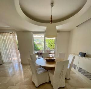 een eetkamer met een tafel en witte stoelen bij Gorgeous Family Pool Villa In Gocek in Göcek