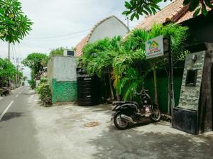 una motocicleta estacionada frente a un edificio en Kinton Guesthouse, en Nusa Penida