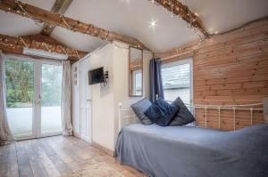 a bedroom with a bed in a room with wooden walls at The Lodge - 1 Bedroom - Freshwest Beach Retreat in Pembroke